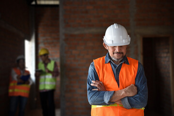 Depressed civil engineer standing with folded arms  having trouble working at construction site
