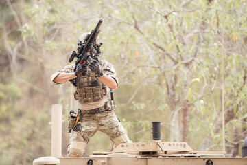 Soldiers in camouflage uniforms hold weapons ready to fire on the roof of a military communication...
