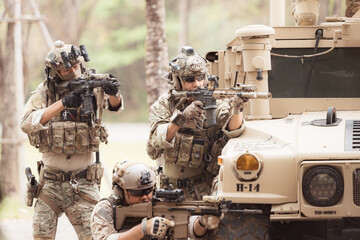 Soldiers in camouflage uniforms hold weapons ready to fire, By hiding on the side military...