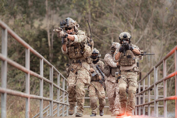 Soldiers in camouflage military uniforms carrying weapons, Reconnaissance missions in the tropical...