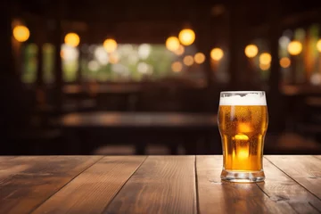  A glass of beer on a wooden table. Blurred background. © MadMouse