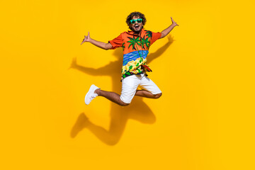 Fototapeta na wymiar Full size photo of satisfied overjoyed man dressed print shirt flying screaming celebrate vacation isolated on yellow color background