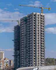 Beautiful blue sky behind two tall buildings in Sunlight , under construction in fast growing city...