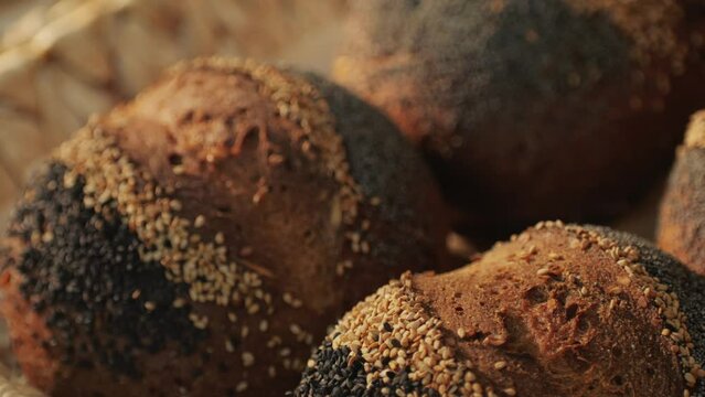 Fresh artesian bread on bakery shop close-up. Bread with black poppy garnish on top and white flour on top. Artisan bread is making by skill bakers using natural and