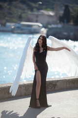 gentle angel with white wings in a black dress