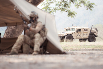 Portrait of soldiers in camouflage uniforms hold weapons in front of a field tent, Prepare for...
