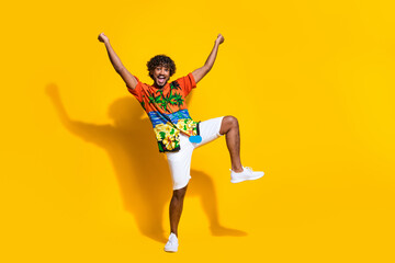 Fototapeta na wymiar Full length photo of overjoyed guy wear hawaii print shirt raising fists up win betting scream yeah isolated on yellow color background