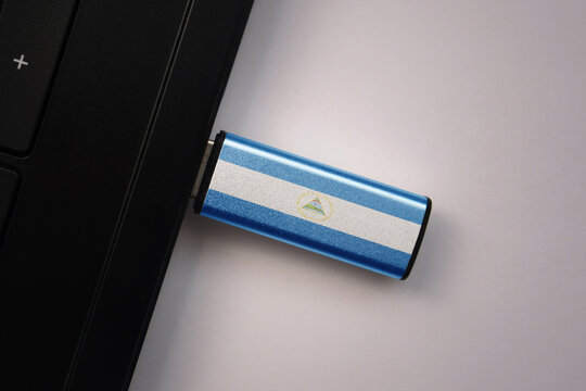 usb flash drive in notebook computer with the national flag of nicaragua on gray background. - Powered by Adobe