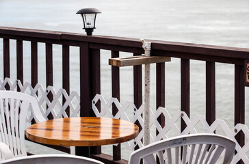table and chairs at the seaside with a wooden fence