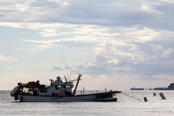 Obraz premium Fishing boat on the sea under the huge clouds