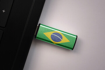usb flash drive in notebook computer with the national flag of brazil on gray background.