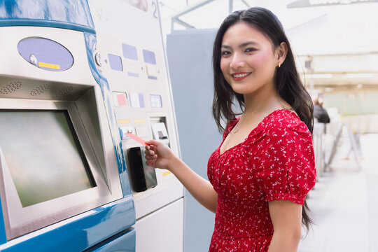 Woman using automated teller machine in casual attire