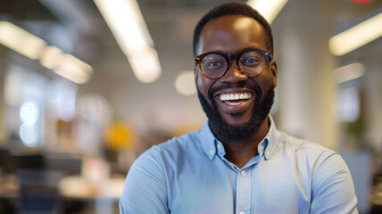 Cheerful man in an office environment, radiating positivity with a bright smile.
