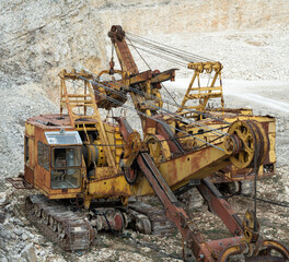 Old rusty yellow equipment in limestone quarry