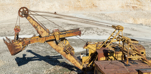 Old rusty yellow equipment in limestone quarry