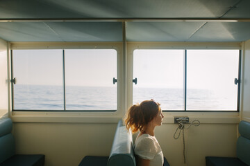 Woman looking out to sea from inside a cabin