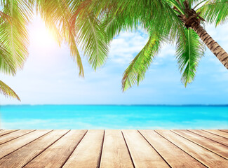 Old wooden table with turquoise water, coconut palm trees and blue sky background. Summer beach holiday concept. - 757421975