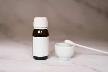 On the table with a bowl and a cotton swab there are two glass bottles for face peeling in the...