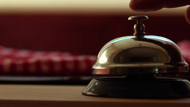 Hand rings bell on counter for service attention