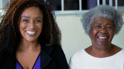 African American Adult daughter authentic interaction with elderly 80s mother exchanging glances...