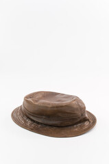 immagine di vecchio cappello floscio in pelle marrone su superficie bianca - obrazy, fototapety, plakaty