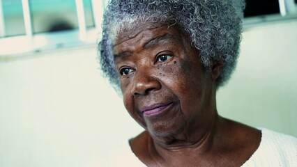 One pensive elderly black woman with gray hair and wrinkles. 80s African American portrait face...