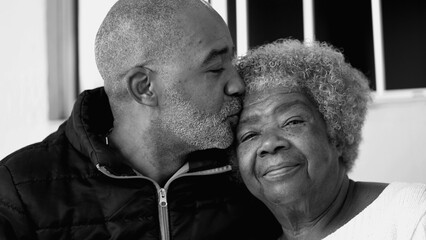 Loving tender moment of Adult 50s son kissing elderly senior 80s mother in forehead, Portrait of...