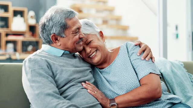 Senior couple, hug and laughing on sofa with conversation for funny memory with love, care and bonding. Old man, elderly woman and happy with embrace, connection and remember with comic chat in home