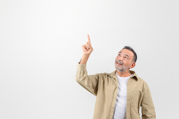 Place For Ad. Smiling senior man pointing up at copy space