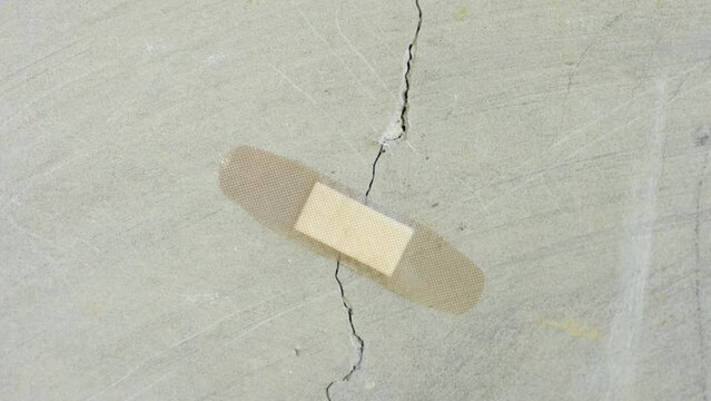 a patch is stuck on a crack in a concrete wall. Unscrupulous repair concept.	