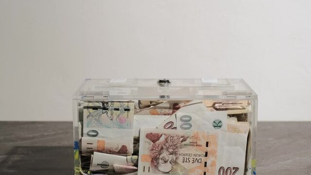 giving Charity in nominal 100 Euro banknotes to a transparent donation box for money donation. A financial support, collects money for a noble cause. The act of giving supports charitable initiatives.