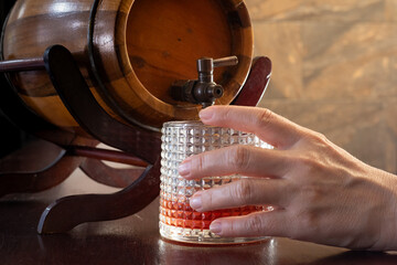 Detail of a Hands Serving a Drink from a Barrel