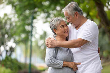 senior couple in love, embracing and holding hands together in the park