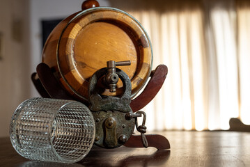Locked barrel of liquor with padlock and upside down glass on the table