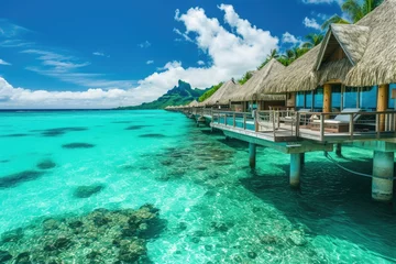 Fototapete Bora Bora, Französisch-Polynesien A beautiful beach with a clear blue ocean and a few small houses on a pier