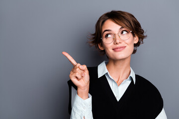 Photo of smart dreamy lady assistant dressed black vest eyewear looking pointing finger empty space...