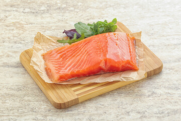 Raw salmon fillet over board