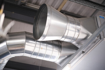 Industrial metal air flow and air conditioning pipes on the ceiling of an industrial factory....