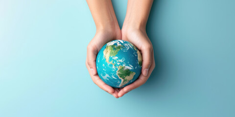 Two hands gently cradling a small globe against a serene blue background, symbolizing care and protection for the Earth.