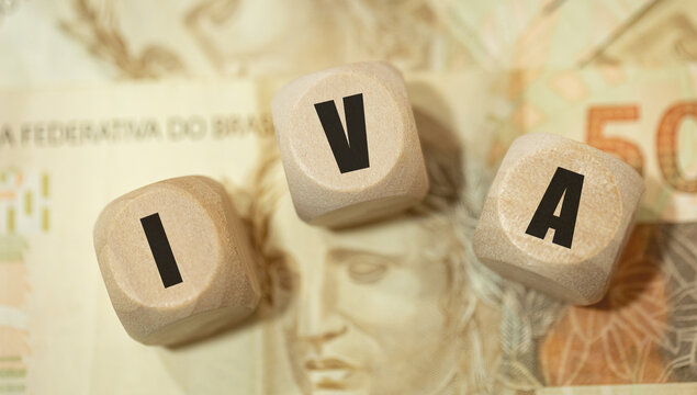 A abreviatura IVA para  Imposto sobre Valor Agregado escrita em dados de madeira na linguagem Portugu&ecirc;s do Brasil. Notas do Real Brasileiro na composi&ccedil;&atilde;o. 50 Reais. Economia Brasileira.