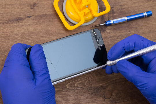 the process of opening a phone with a scalpel, repairing the battery and replacing glass, close-up