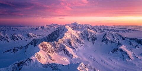 Sunrise over snowy mountain peaks from above
