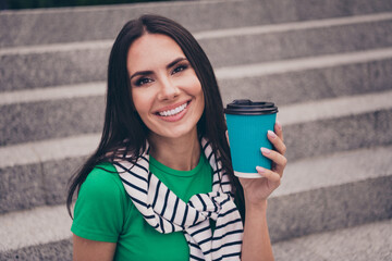 Photo of cheerful lovely woman dressed stylish clothes jumper on shoulders holding plastic cup...