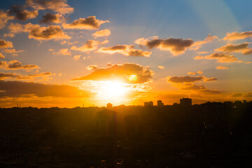 Colorful sunset sky with clouds and the setting sun over the city of Istanbul, Turkey in the evening - apartment, residential buildings silhouettes. Urban, cityscape, cloudscape and summer concept