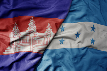 big waving national colorful flag of honduras and national flag of cambodia.