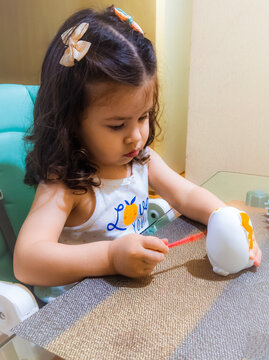 Ni&ntilde;a feliz y concentrada jugando con pinturas y temperas