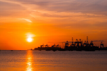 Fototapeta premium View of amazing dramatic sunset sky with clouds and setting sun over the cargo port and the Sea of Marmara surface in the evening in Turkey. Cloudscape and summer concept