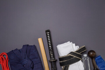 A set of traditional martial arts items and clothing on a gray background with space for text.