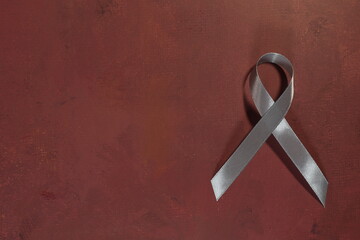Gray ribbon on dark red background.