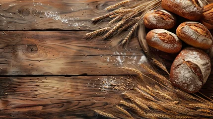 Poster Freshly baked bread and wheat grains arranged on a wooden surface. © Bahram